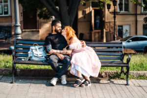 Beautiful dating couple hugging on a bench